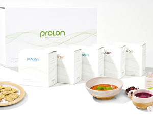 Prolon meal replacement products including boxes, a bowl of soup, and crackers on a white background