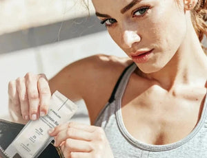 Woman taking protein bar out from a bag 